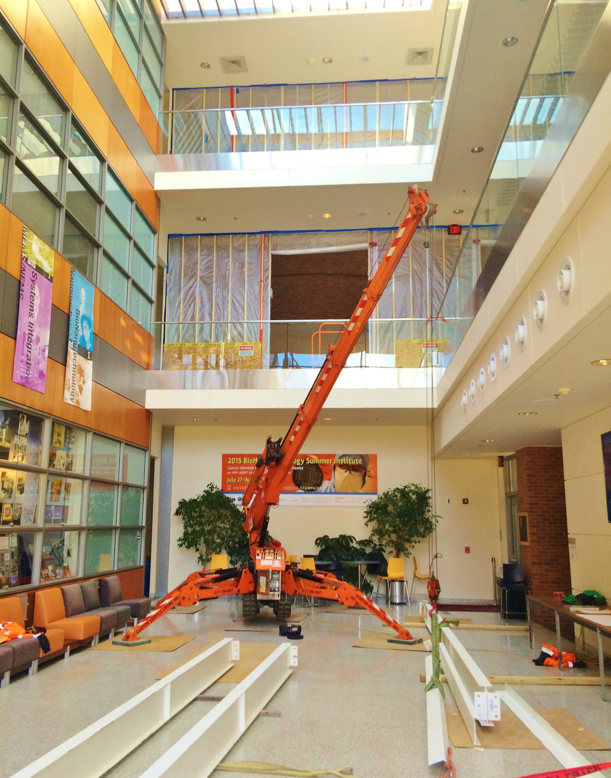 Jekko mini crane lifting beams inside an academic building.