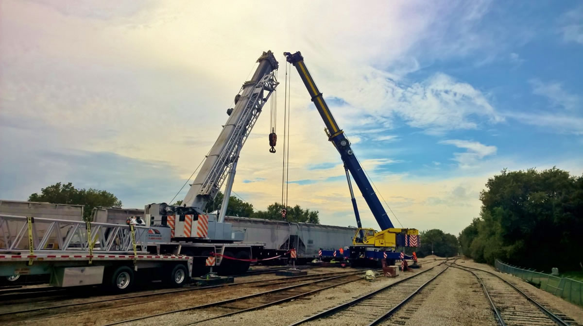 two 275 ton hydraulic cranes assist a rail car