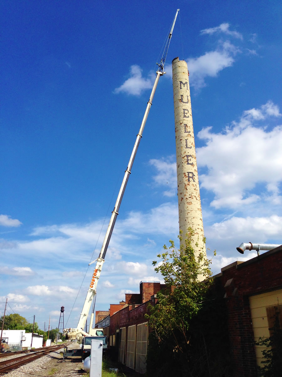 Smoke stack is being deconstructed by a 90 ton hydraulic crane.