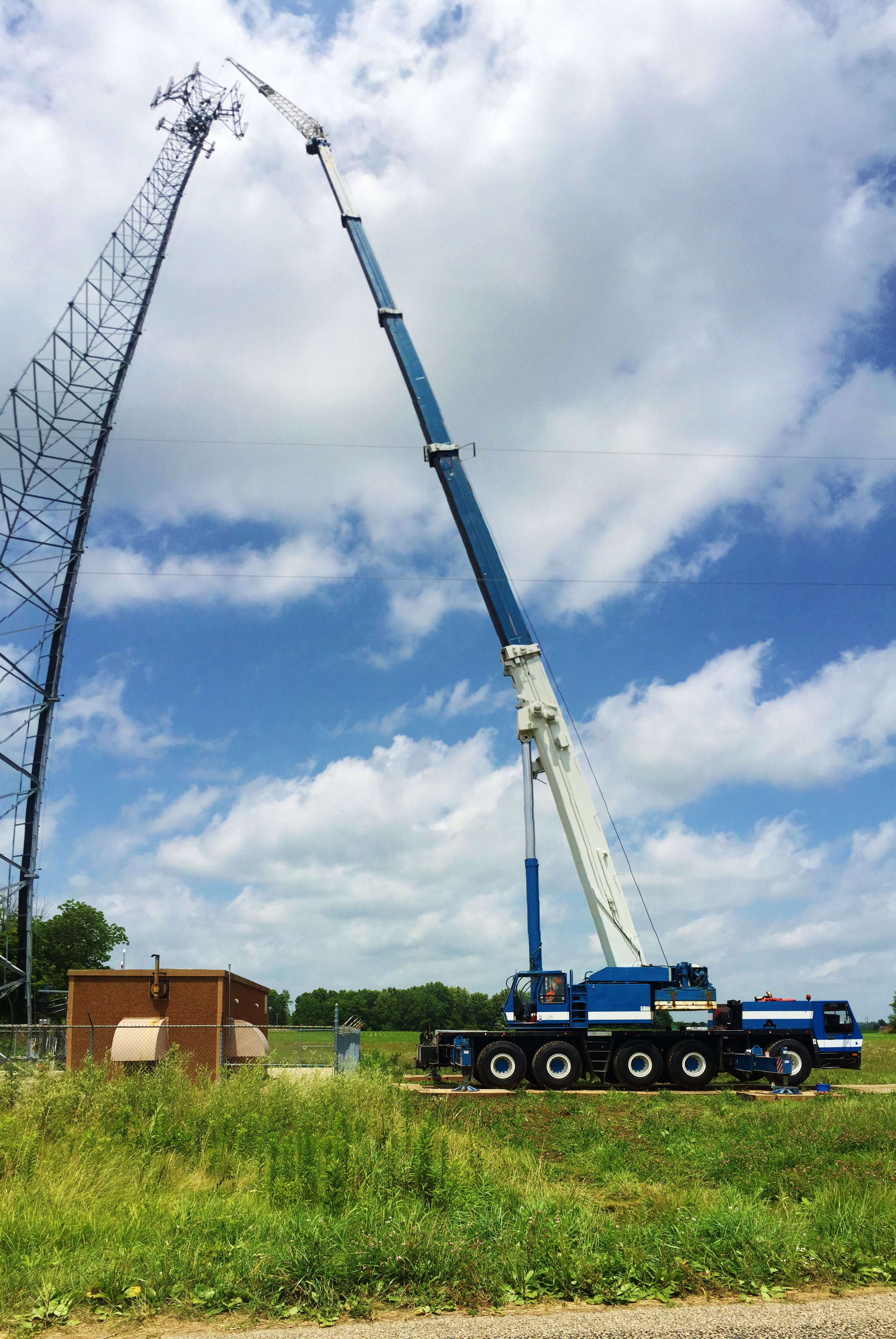 175 ton crane reaches high to hoist new antennas for a cell tower.